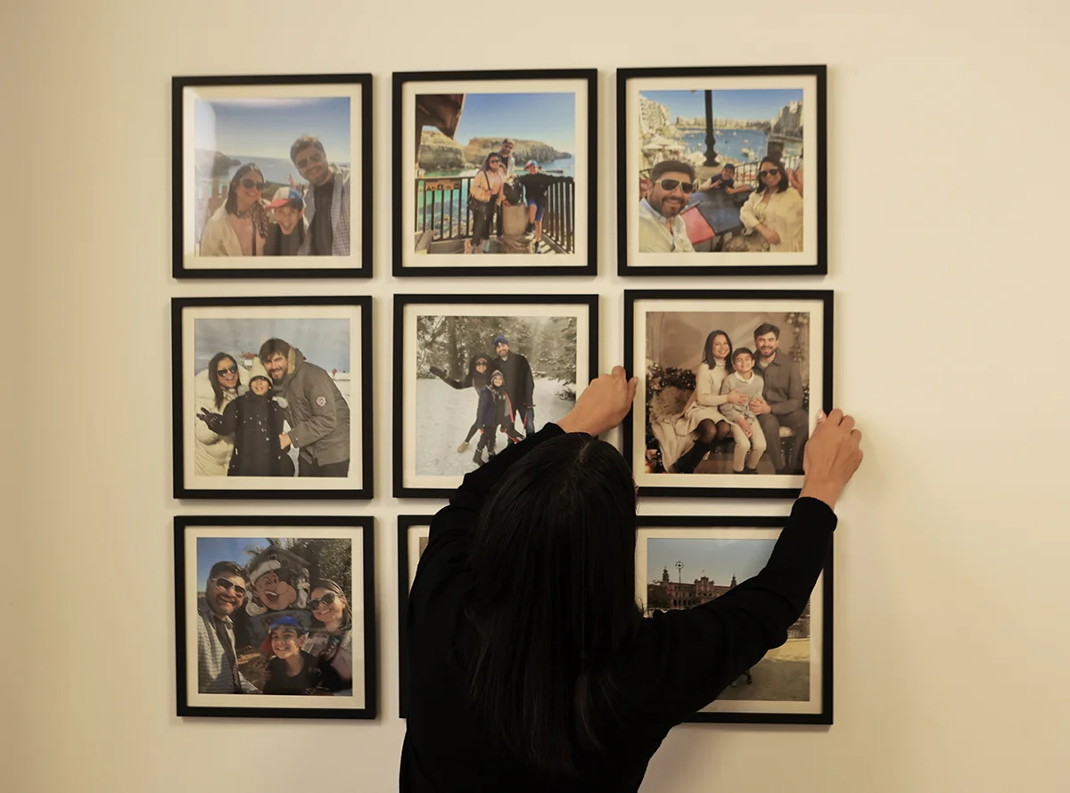 Composição real de nove quadros FrameU pretos com fotografias de família, a ser alinhada na parede